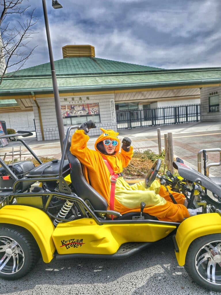 Kartzilla go-kart rider in a costume poses in front of Ryogoku Sumo Stadium in Tokyo, Japan.