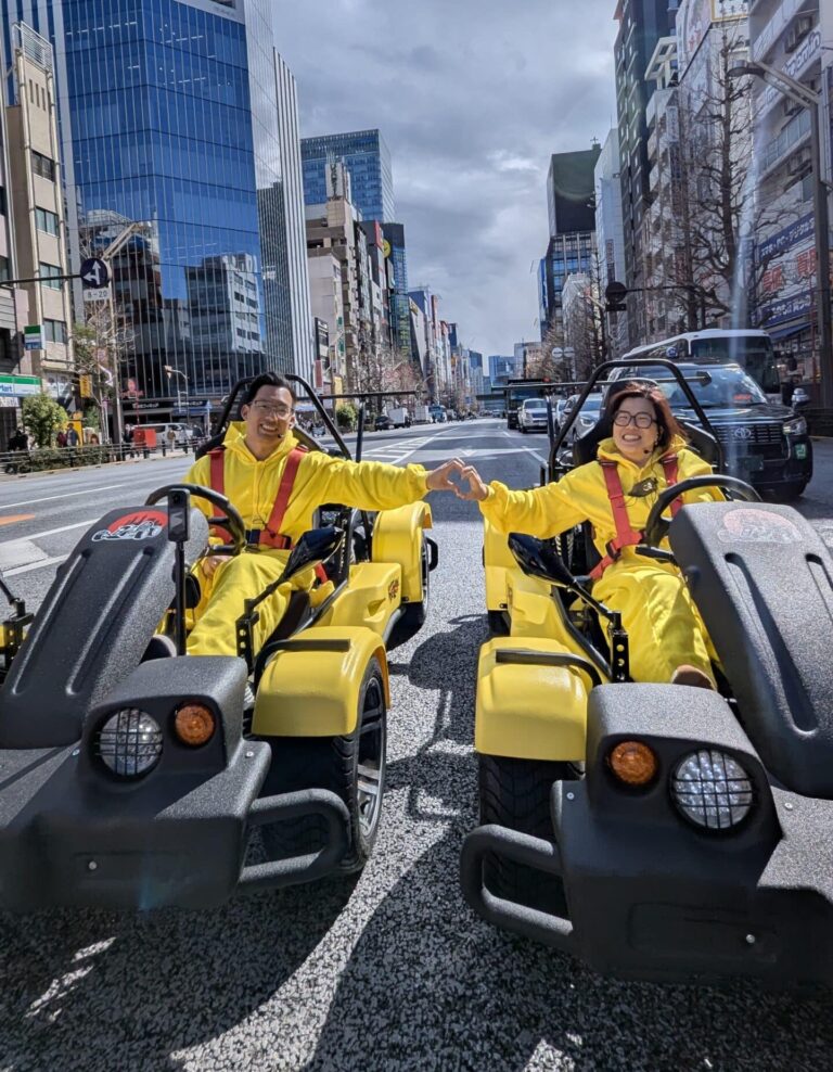Couple forming a heart with hands while go-karting through Akihabara with Kartzilla Go Kart.