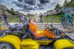 Woman in a Tigger costume posing in a Kartzilla street kart under cherry blossoms along Daikancho-dori Street near the Imperial Palace in Tokyo during a Mario Kart style tour.