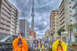 Go-kart riders dressed in costumes posing with Tokyo Skytree in the background during a Kartzilla Go Kart tour.