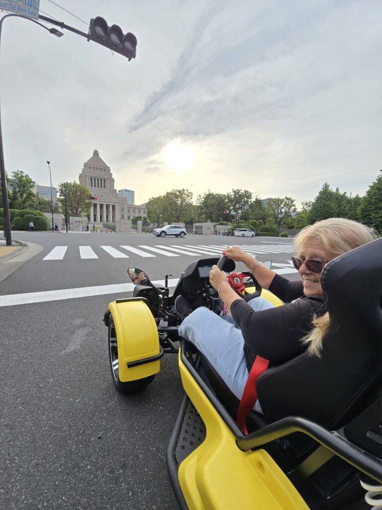 Kartzilla Go Kart rider cruising near Tokyo’s National Diet Building in a yellow street kart during a Mario Kart style go-kart tour.
