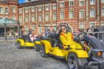 Street kart riders in Mario Kart-style go-karts driving through Tokyo Station with Kartzilla Go Kart.