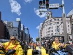 Tourists wearing costumes driving Mario Kart style go-karts through Ginza 4-chome in Tokyo during a street kart tour with Kartzilla Go Kart.