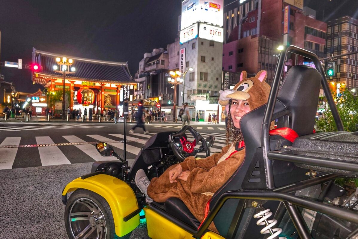 Kartzilla go-kart guest in animal costume parked at night beside Kaminari-mon Gate in Asakusa, Tokyo